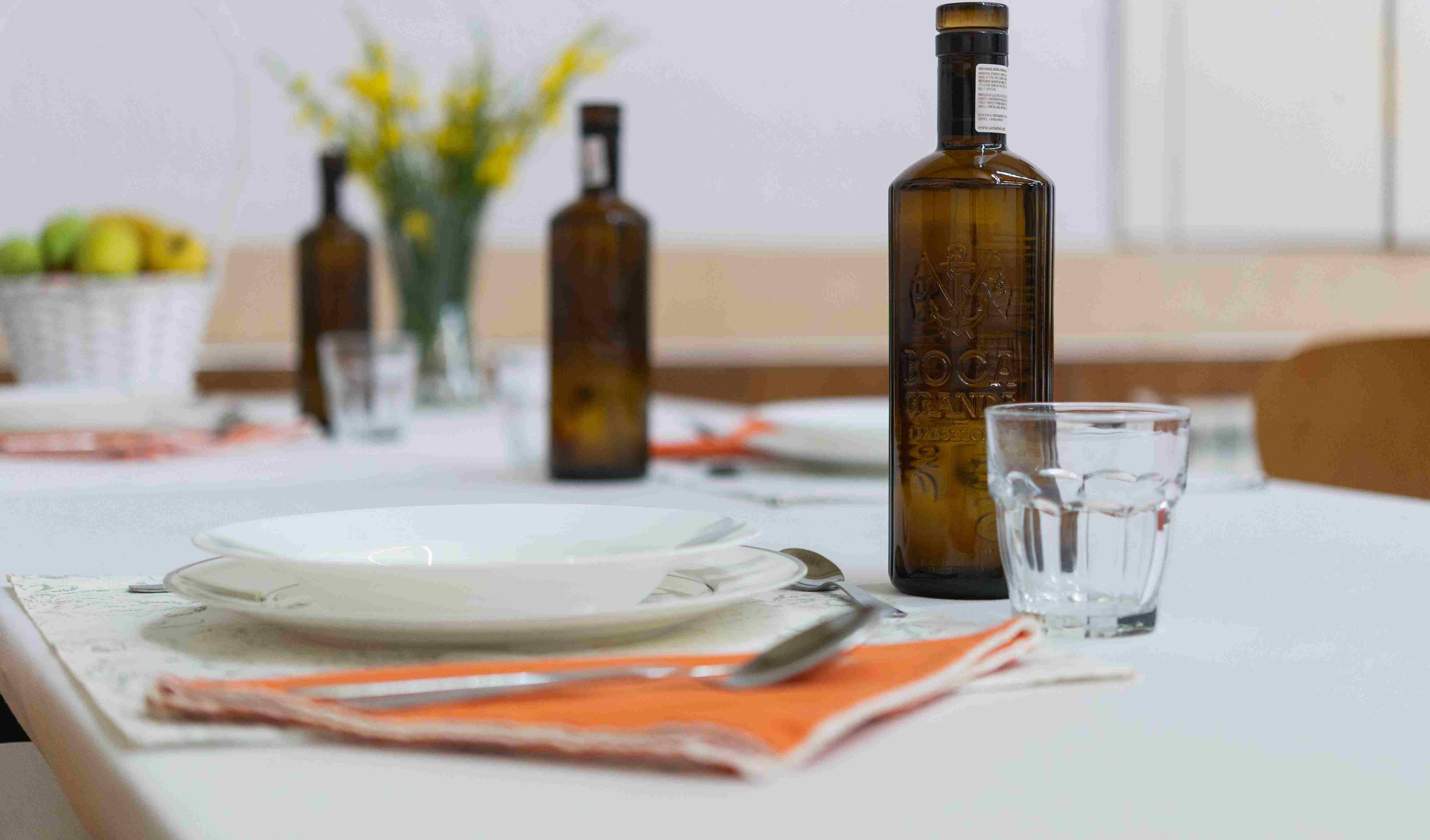 Taula parada amb ampolles d'oli, plats i vassos